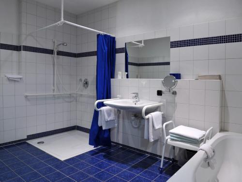 Pommersfelden格鲁纳鲍姆酒店的浴室配有水槽、淋浴和浴缸。