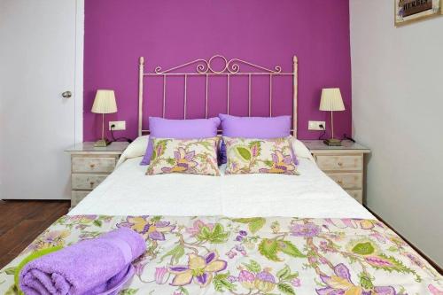 科尔多瓦De Patios的一间卧室配有一张带紫色墙壁和紫色枕头的床