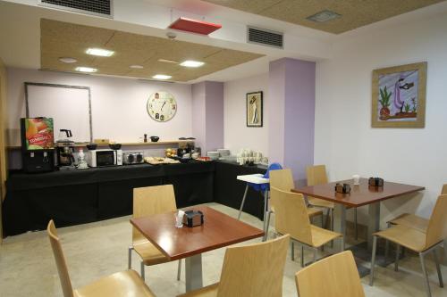 布尔戈斯阿尔达恩特雷亚哥斯酒店的一间带2张桌子和椅子以及柜台的餐厅
