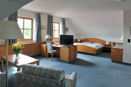 Pommersfelden格鲁纳鲍姆酒店的酒店客房设有床和客厅。