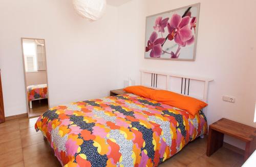 宏达海滩Villa Mela的一间卧室配有一张带五颜六色棉被的床