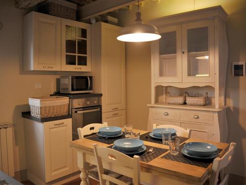 皮斯托亚Appartamento il Battistero的厨房配有带椅子的木桌和桌子。
