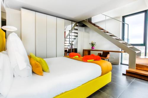 巴塞罗那桑特斯科斯莫公寓的一间卧室配有白色的床和黄色及橙色枕头