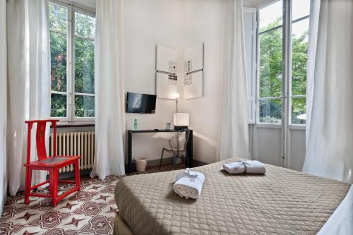 卢卡卢克里西亚卢卡别墅旅馆的一间卧室配有一张床、一张红色椅子和窗户