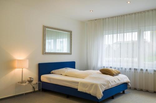 勒讷施瓦酒店的一间卧室设有蓝色的床和窗户。