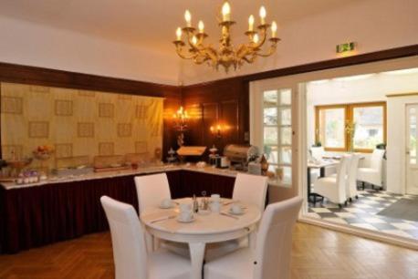 汉堡施密特酒店的一间设有白色桌子和白色椅子的用餐室