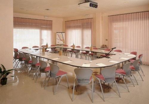 鲁别拉柯尔特酒店的大型会议室,配有大桌子和椅子