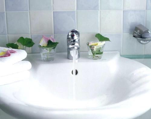 葛伦坦马勒罗马酒店的浴室水槽配有水龙头和两杯玻璃杯