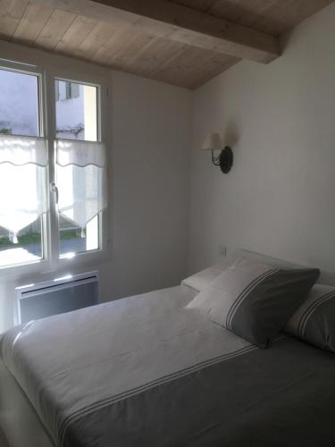 雷岛圣玛丽Locations Ile de Ré的白色的卧室设有床和窗户