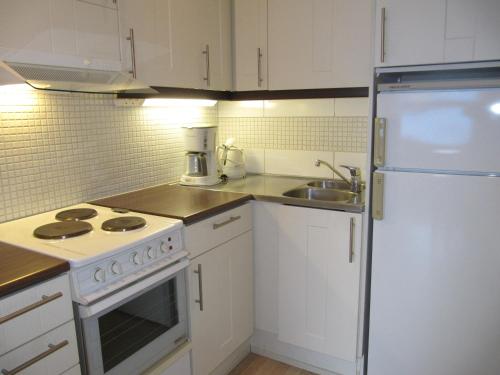 萨利色尔卡Lapin Kutsu Apartments的厨房配有白色橱柜和白色冰箱。
