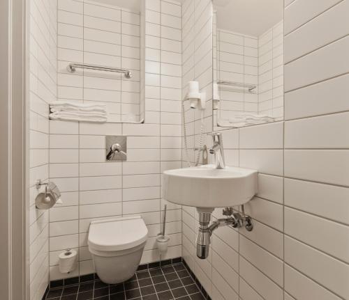 奥斯陆MediInn Hotel Oslo的白色的浴室设有卫生间和水槽。