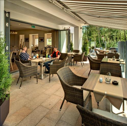 格拉尔-米里茨Hotel Haus am Meer的两人坐在带桌椅的餐厅