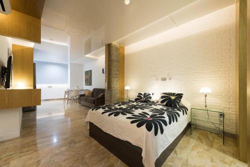 大加那利岛拉斯帕尔马斯Suites Garden Loft Andy Warhol的一间卧室设有一张床和砖墙