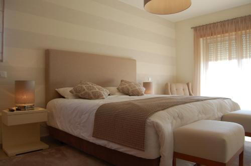 奥比多斯Villa Golf 6的一间卧室设有一张大床和一个窗户。