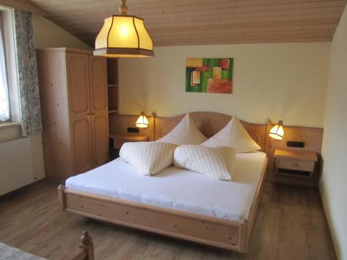 弗林肯贝格Appartementhaus Sennhüttn的一间卧室配有带白色床单和枕头的床。
