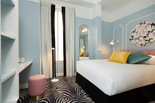 巴黎巴黎巴斯特尔酒店的一间卧室配有一张大床和镜子