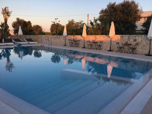 滨海波利尼亚诺Carone Suite-Charme&Pool by Bluette的一个带椅子和墙壁的游泳池