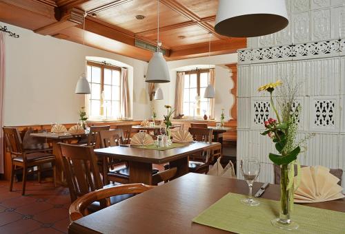古坦泽尔赫贝尔Hotel Restaurant Klosterhof的餐厅设有木桌和鲜花椅子