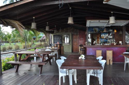 基督教堂市Frangipani Apartment的一间带木桌椅的餐厅和一间酒吧