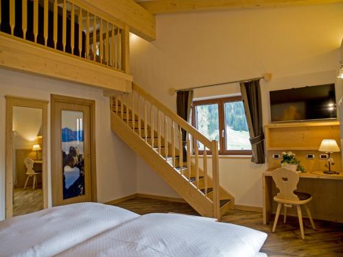 博萨迪法萨埃尔帕斯特酒店的一间卧室设有楼梯、一张床和一张书桌