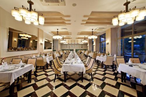 科纳克勒Saphir Hotel & Villas的一间设有白色桌椅的用餐室