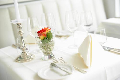 圣英贝特Hotel Restaurant Sengscheider Hof的花瓶上的白色桌子