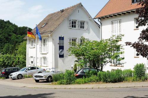 圣英贝特Hotel Restaurant Sengscheider Hof的一座白色的房子,前面有汽车停放