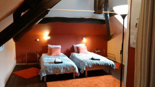 DohanB&B Le Courtil的一间卧室设有两张双层床,拥有橙色的墙壁