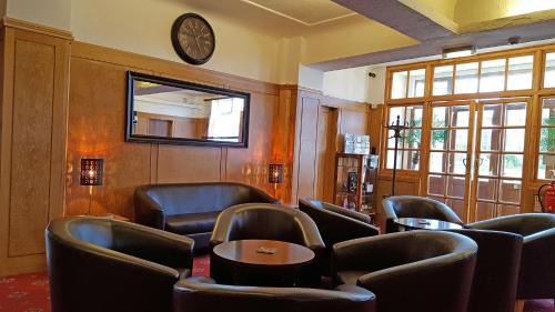 尚克林梅德汉斯德酒店的一间设有椅子和墙上时钟的等候室