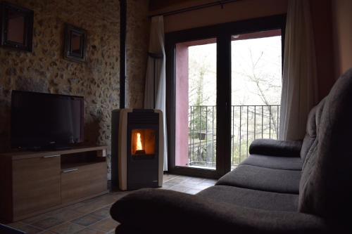圣费柳-德帕利亚罗尔斯卡拉塔姆布纳乡村别墅的客厅设有壁炉和电视。