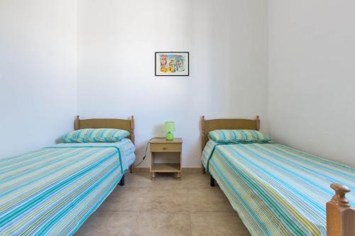普罗斯西托角Serra degli Angeli by BarbarHouse的两张睡床彼此相邻,位于一个房间里