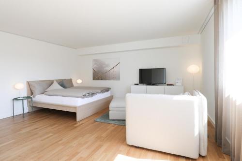 Uzwil豪斯一号服务公寓酒店的白色卧室配有床和沙发