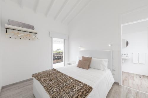 马达莱纳Insula Atlantis Apartments的白色的卧室设有床和窗户