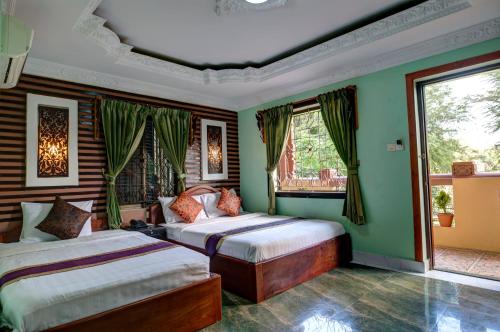 金边RS II酒店的配有两张床铺的绿色墙壁和窗户