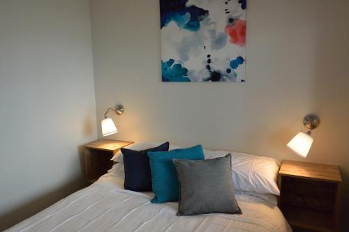 Erowal Bay顿格万假日住宿酒店的一间卧室配有一张带蓝色枕头的床和两盏灯