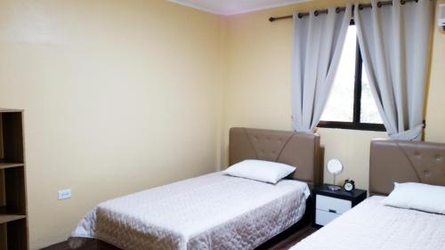 查兰卡诺亚塞班家庭公寓的一间卧室设有两张床和窗户。