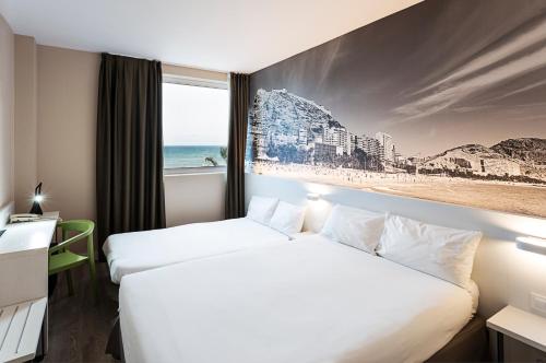阿利坎特B&B HOTEL Alicante的一张位于酒店客房的两张床,享有海滩美景