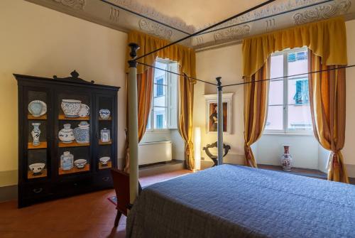 皮斯托亚Dimora Storica Palazzo Puccini的一间卧室配有一张床、梳妆台和窗户。