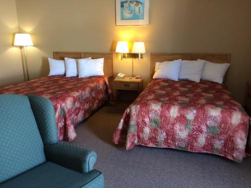圣安东尼港湾宾馆的酒店客房,配有两张床和椅子