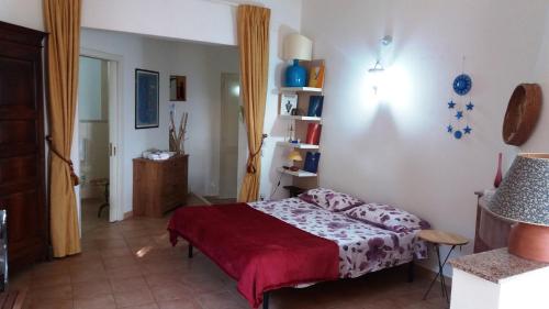 RoccaforzataPanoramico con giardino的一间卧室配有一张带红色毯子的床