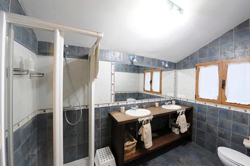 La Santa Espina拉布拉多之角乡村民宿的蓝色瓷砖浴室设有2个水槽和淋浴