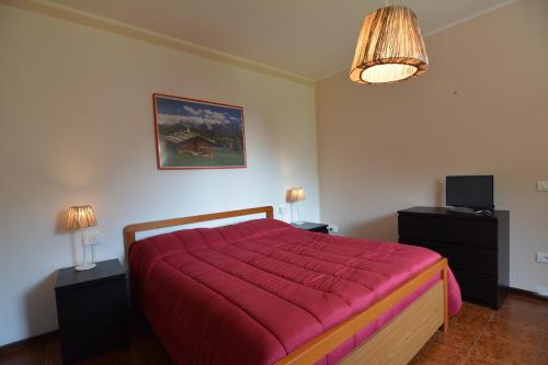 圣佩莱格里诺温泉卡德尔米克拉斯住宿加早餐旅馆的一间卧室配有一张带红色毯子的大床