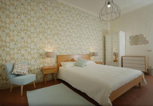 彼得拉桑塔Le camere di Sementis的卧室配有白色的床和蓝色椅子