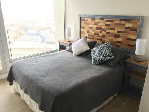 科金博Apartamento en Club Oceano的一间卧室设有一张大床和大窗户