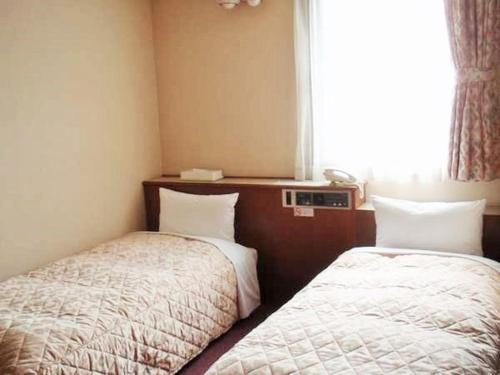 东京西新宿绿色酒店的酒店客房设有两张床和窗户。