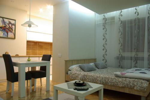 尼什Square Studio Apartment的一间卧室配有一张床、一张桌子和一张桌子