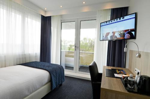哈莱姆哈勒莫里德德佐特因瓦酒店的酒店客房配有一张床、一张书桌和一台电视。