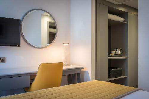 柯罗格伦都柏林机场马尔丹酒店的一间带桌子和镜子的用餐室