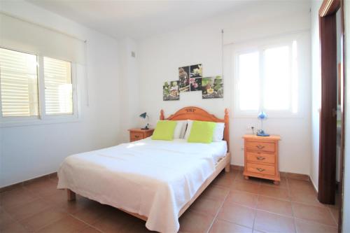 圣安东尼奥Villa Sofia的一间卧室配有一张床、一个梳妆台和两个窗户。