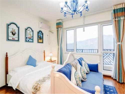 密云途旅豪华观景公寓的一间卧室配有一张带蓝色枕头的床和吊灯。